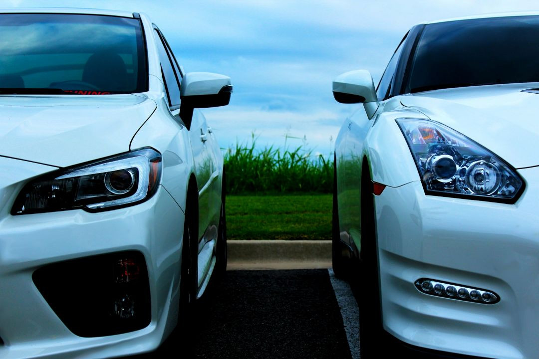 close-up front view of two white performance vehicles parked next to each other