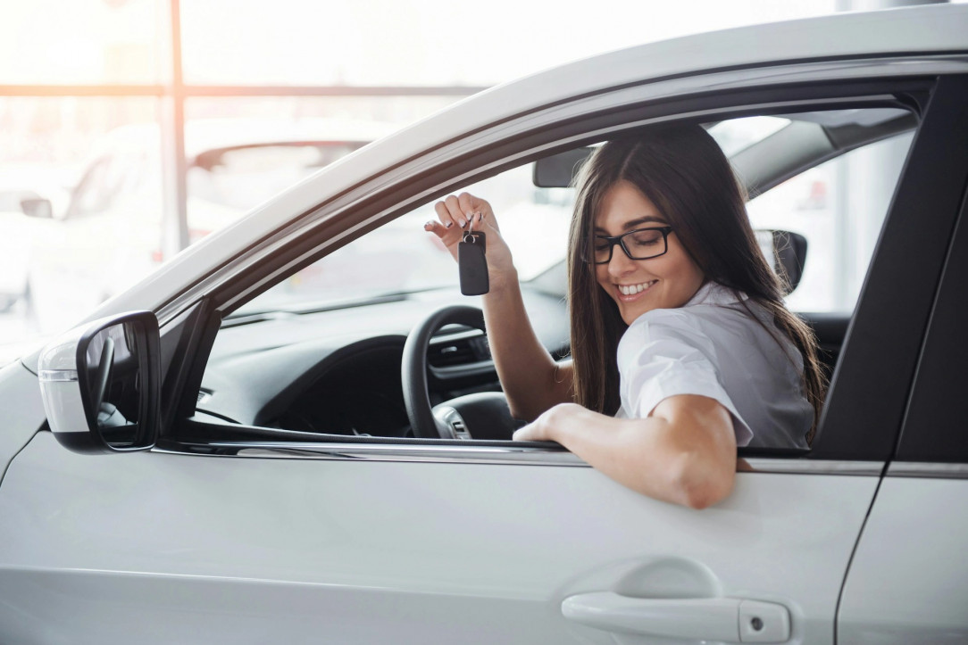 Mujer con llaves de coche en el convertible.