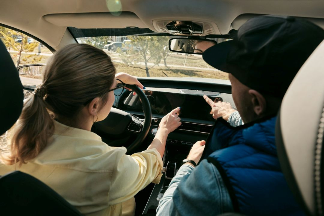potential car buyer and salesperson sitting inside a vehicle during a test drive