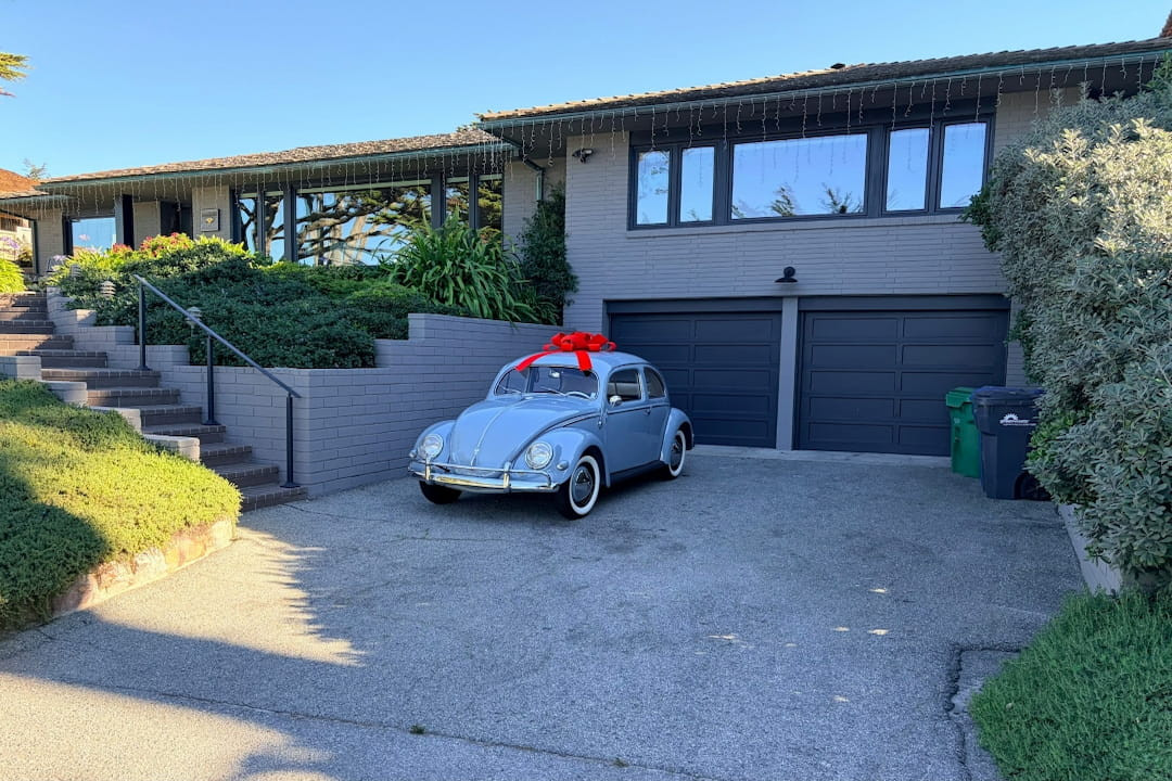 vintage blue Volkswagen Beetle with a large red bow